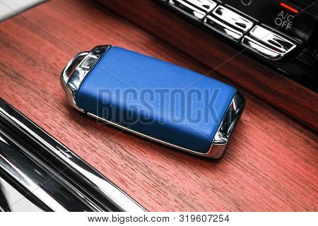 Closeup Inside Vehicle Of Wireless Blue Leather Key Ignition On Natural Wood Panel. Wireless Start E