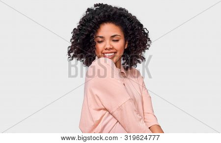 Pleased Dark-skinned Young Woman Dressed In Pink Shrit, Feels Happy. African American Female Smiling