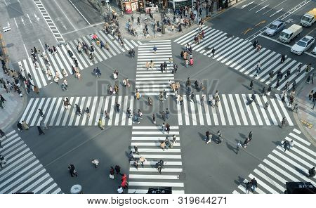 People Passing The Street Crossing In Ginza District, Tokyo. Crosswalk. Intersection In Tokyo.