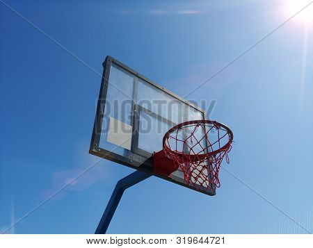 Side View Of Basketball Ring Basket Outdoor With Clear Blue Sky On Background And Bright Sun At Corn