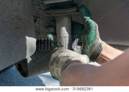 Hands In Defense Gloves Mechanics To Repair The Suspension On The Car. Work With A Wrench. Self-repa