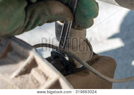 Hands In Defense Gloves Mechanics To Repair The Suspension On The Car. Work With A Wrench. Self-repa