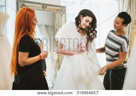 Beautifu bride choosing wedding dress in a wedding salon