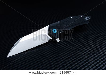 Folding Pocket Knife Diagonally. Black Background. Shiny Blade.