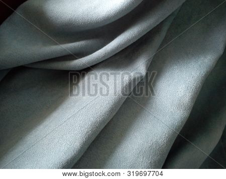 Close-up Of Velvety Thick Fabric For Curtains Of Gray-blue Color Pleated With The Play Of Chiaroscur