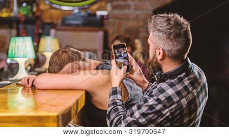 Man Drunk Fall Asleep And Guy With Smartphone. Hipster Taking Photo Drunk Friend. Drunk Friends In B