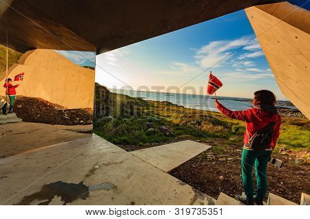 Tourist Woman With Norwegian Flag Enjoying Sea Coast View From Bukkekjerka Rest Stop Area On Andoya 