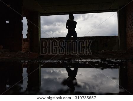 Silhouette Of Woman Caucasian Hip Hop Dancer, Freestyling Outdoors In An Old Abandoned Building With