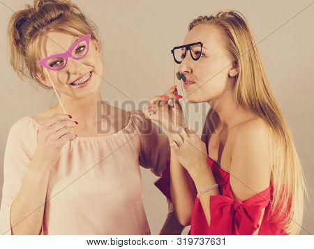 Happy Two Women Holding Paper Decoration Photo Booth Mask Glasses And Moustache On Stick, Having Fun