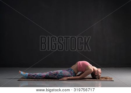 Young Caucasian Woman On A Yoga Mat Doing Fish Pose.