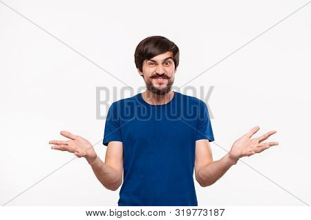 Good Looking Brunet Man In A Blue Shirt With Beard And Mostaches Shouting Shrugging His Shoulders Be