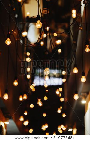 Burning Bulb Shines Weakly On The Background Blurred Yellow Lights