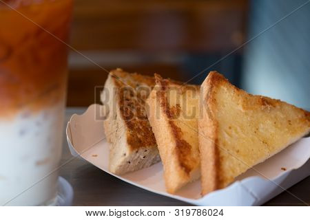 Three Piece Of Triangle Of Garlic Bread In White Paper Tray