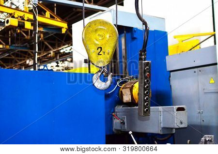 Crane Hook Of The Overhead Crane In The Workshop Of An Industrial Plant.  Push Remote Control Switch