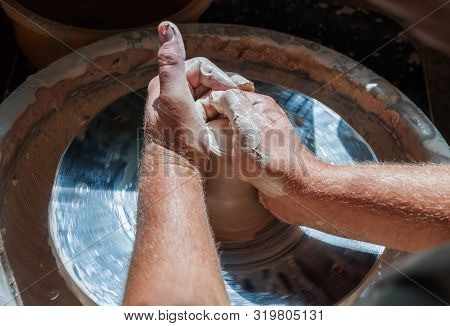 Hands Of A Potter Making Ceramic Clay Product On The Pottery Whee.