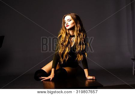 Beautiful Dancer. Girl Model. The Girl Sits In A Hat And Sits On A Table. Girl In A Beautiful Underw