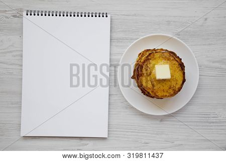 Homemade Corn Meal Johnny Cakes With Butter On A White Plate, Blank Notepad On A White Wooden Backgr