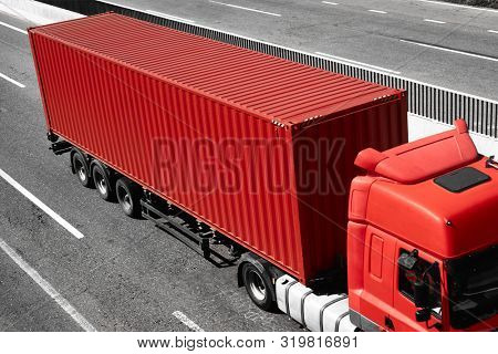 Red truck is going up the road. Cargo transportation concept.