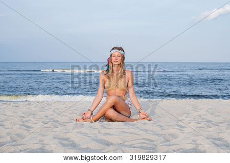 Young Woman Practicing Yoga On The Beach. Gomukasana Pose And Meditation