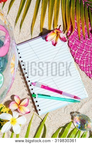 Open Blank Writing Note Pad With Pink And Green Pen On Sand, Surrounded By Green Palm Leafs, Sea She