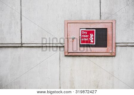 Dry Riser Inlet Box Red On Brick Wall For Emergency Fire Services Water Connection For Hose Brigade 