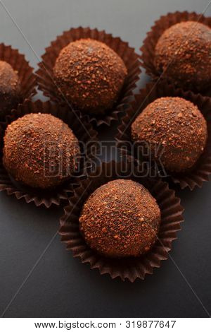 Chocolate Petit Fours Over Black Background. Top View.