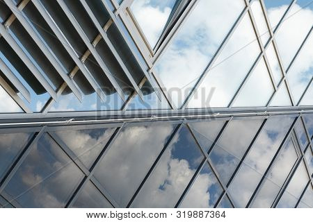 Shiny Glass Wall With Darkening Glass And Sheer Glass Joint With Sky Reflection, Mirrorlike.