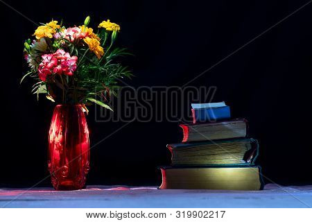 Old Voluminous Tomes Written In Ancient Times Stacked On The Reading Table Of Dark Calm Night. A Bou