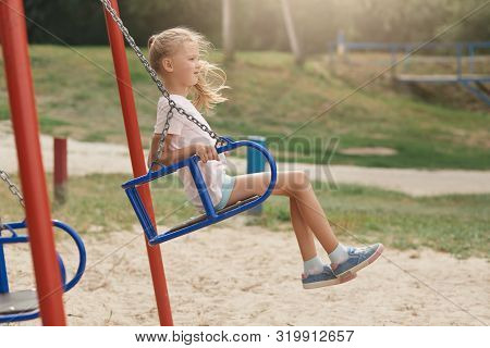 Image Of Child On Swing In Playground Outdoors, Liitle Girl With Ponytail And Casual Clothing, Looki