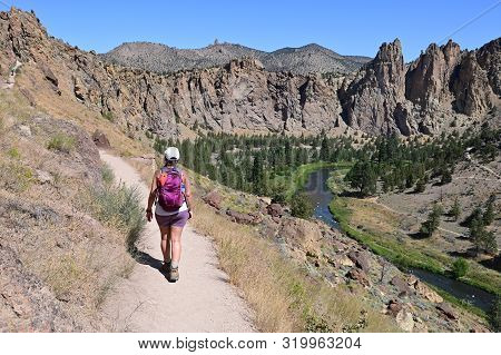 Young Woman On Misery Ridge Trail In Smith Rock State Park Near Terrebonne, Oregon On A Coudless Sum