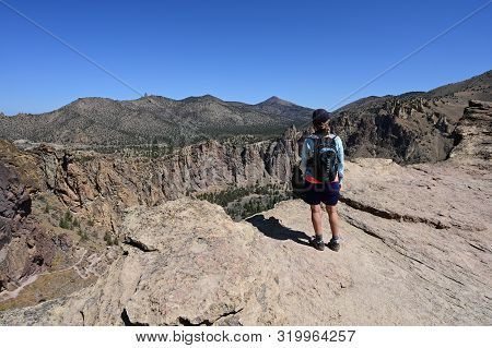 Woman On Misery Ridge Trail In Smith Rock State Park Near Terrebonne, Oregon On A Coudless Summer Da