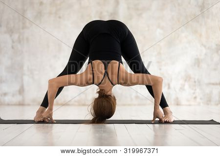 Young Woman Practicing Yoga, Forward Bend, Prasarita Padottanasana