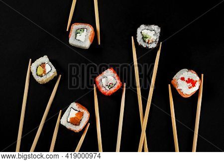 Set Of Japanese Sushi Isolated On Black Background. Top View