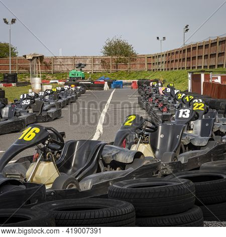 A Panning Shot Of A Racing Kart As It Circuits A Track.