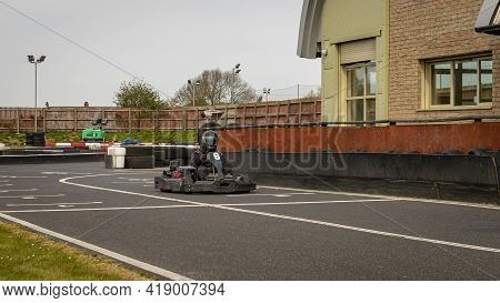 A Panning Shot Of A Racing Kart As It Circuits A Track.