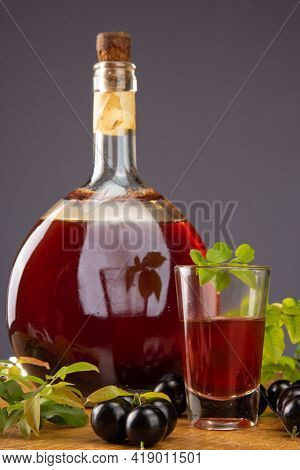 Jaboticaba, Bottle And Glass Of Homemade Brazilian Jaboticaba Liqueur On Wood With Leaves And Branch