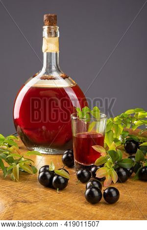 Jaboticaba, Bottle And Glass Of Homemade Brazilian Jaboticaba Liqueur On Wood With Leaves And Branch