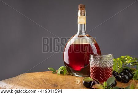Jaboticaba, Bottle And Glass Of Homemade Brazilian Jaboticaba Liqueur On Wood With Leaves And Branch