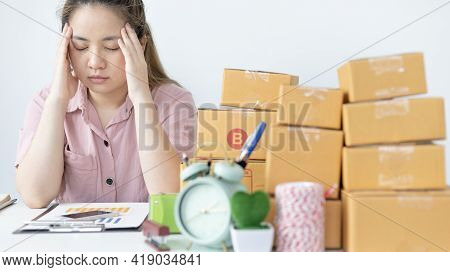 Young woman sitting on a desk is sad or depressed about a sales business, Anxiety and disappointment