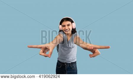 Enjoy Music. Happy Indian Teeneger Girl Listening To Her Favorite Sountrack, Using Wireless Headphon