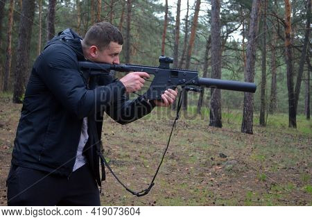 Man with KRISS Vector 9*21 caliber submachine gun in the  forest. Unformal shooting range near Kiev. April 30,2021. Kiev Region, Ukraine