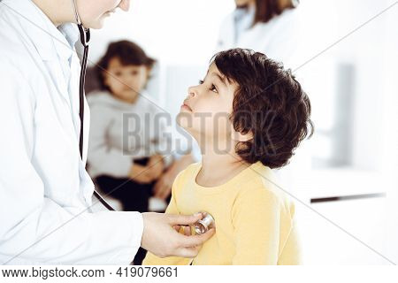 Woman-doctor Examining A Child Patient By Stethoscope. Cute Arab Boy At Physician Appointment. Medic