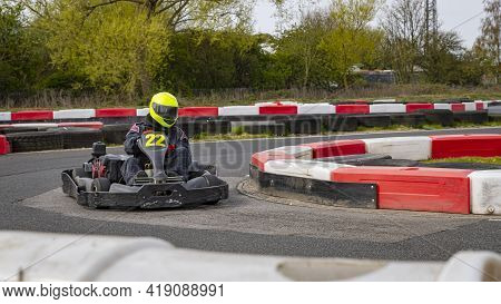 A Panning Shot Of A Racing Kart As It Circuits A Track.