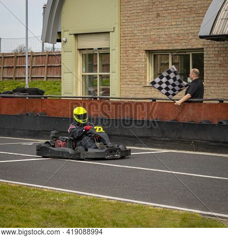 A Panning Shot Of A Racing Kart As It Circuits A Track.