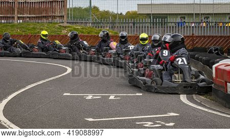 A Panning Shot Of A Racing Kart As It Circuits A Track.