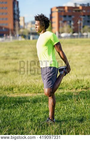 Black Man Stretching His Quadriceps After Running Outdoors.