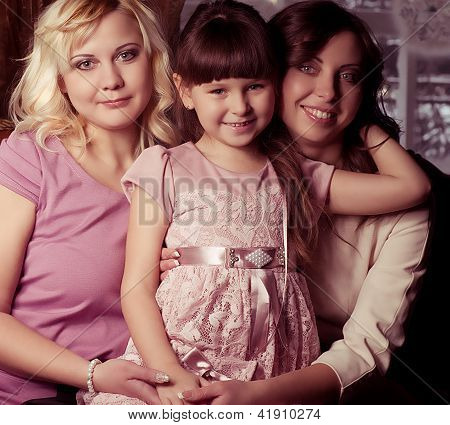 Happy family, young beautiful mother, aunt and her little daughter embracing