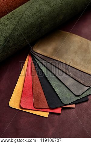 Artificial Leather Samples On A Cow Leather Background. Top View.