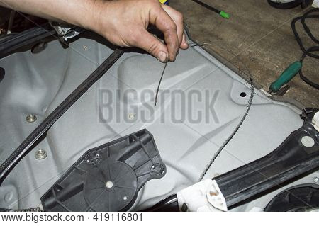 The Torn Cable Of The Car Window Lifter Drive In The Hands Of A Mechanic