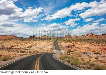 Long Winding Highway Valley Of Fire Nevada, Usa. Blue Cloudy Sky Background